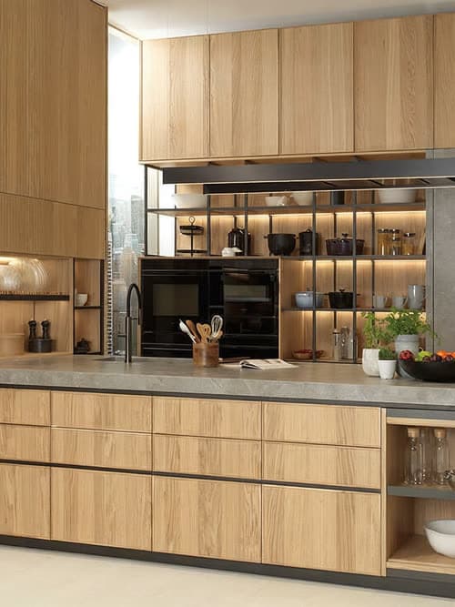 Cocina de madera con isla y estantería iluminada de Porcelanosa en A Pobra do Caramiñal