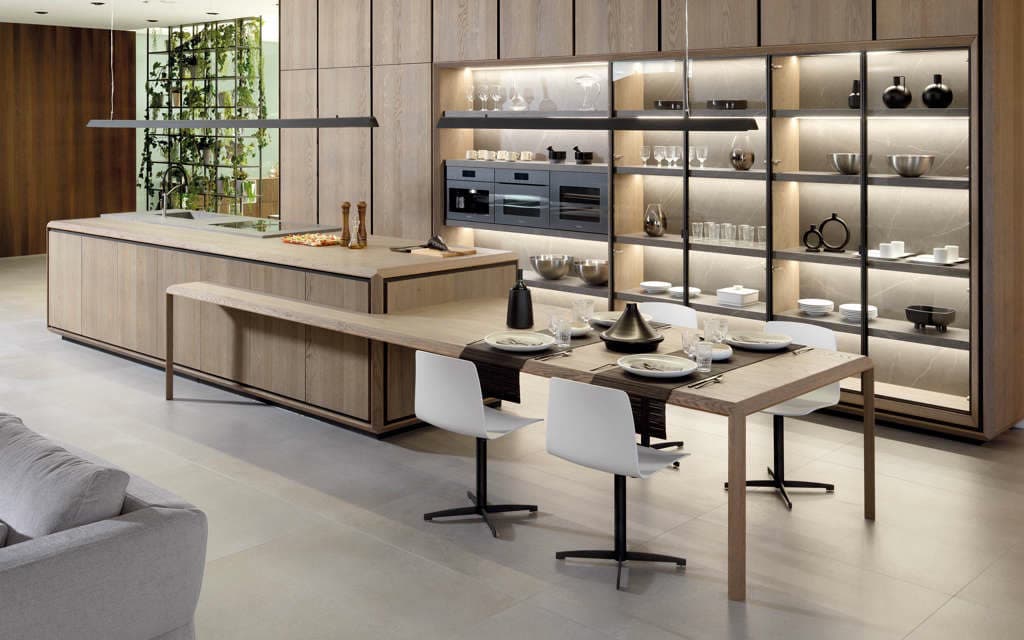 Cocina con isla de madera y estantería iluminada en A Pobra do Caramiñal