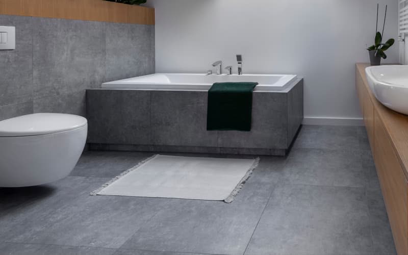 Baño con pavimento porcelánico gris en A Pobra do Caramiñal